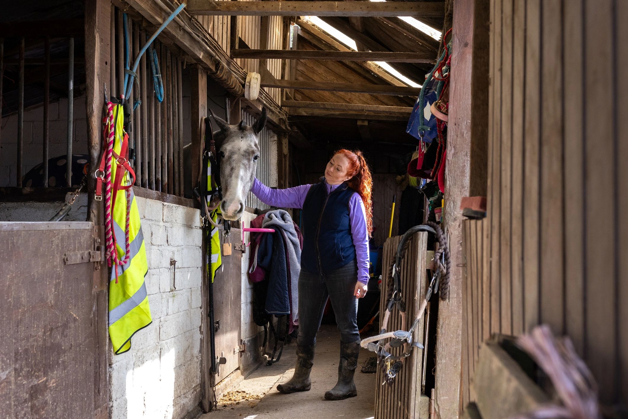 Caregiver with a horse in a stable